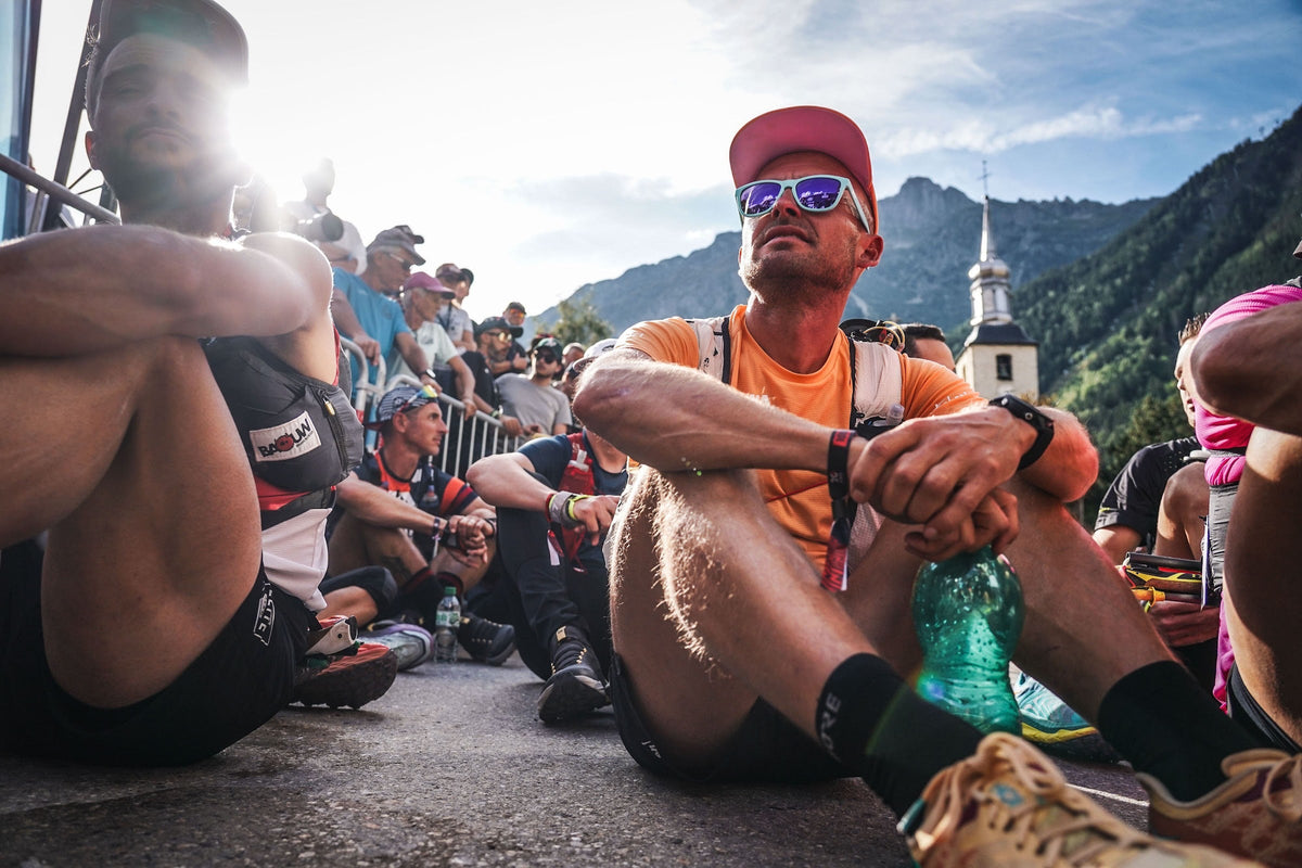 Coureurs attendant assis dans le sas avant le départ de l'UTMB
