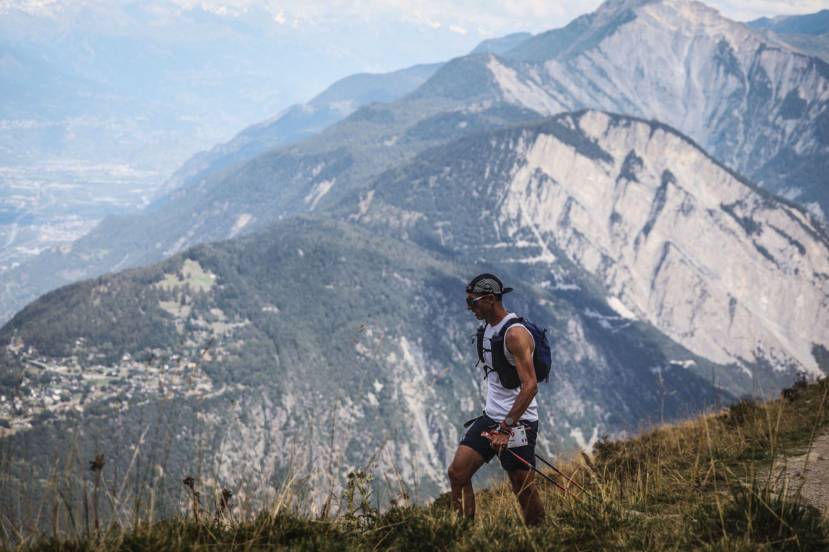 Coureur de l'UTMB sur un sentier de crête dominant la vallée