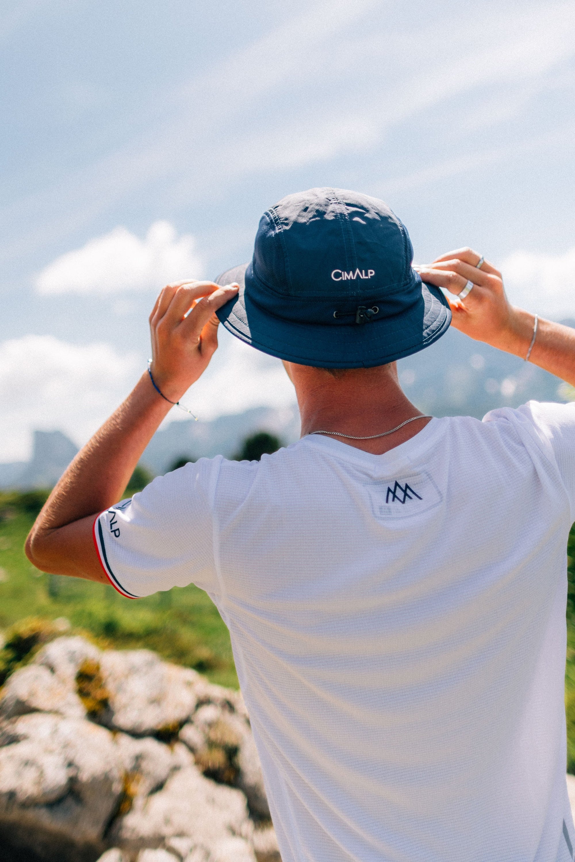 Traileur ajustant sa casquette en montagne