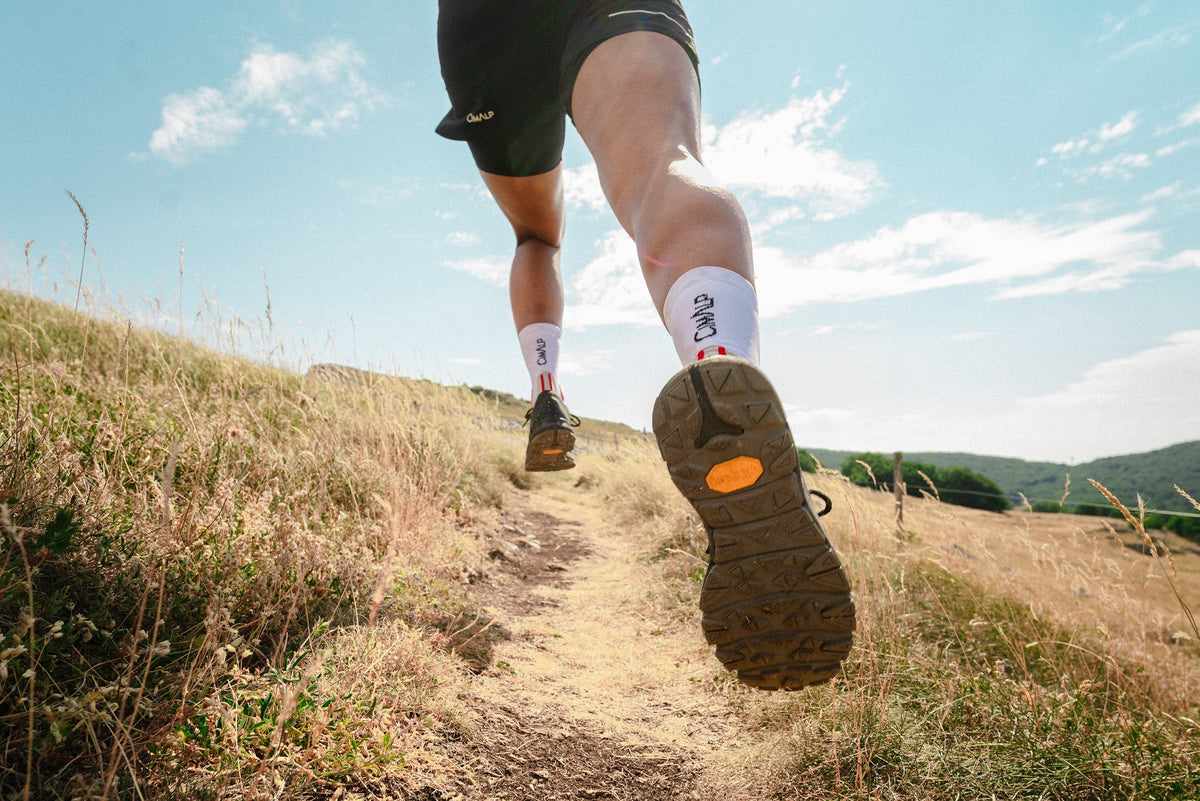 Gros plan sur la semelle d'une chaussure de trail en pleine foulée
