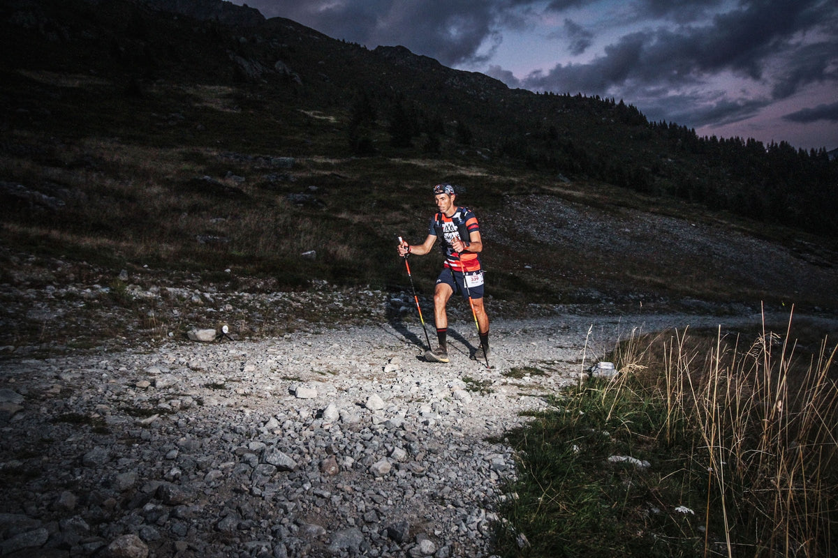 Coureur de l'UTMB sur un pierrier au crépuscule