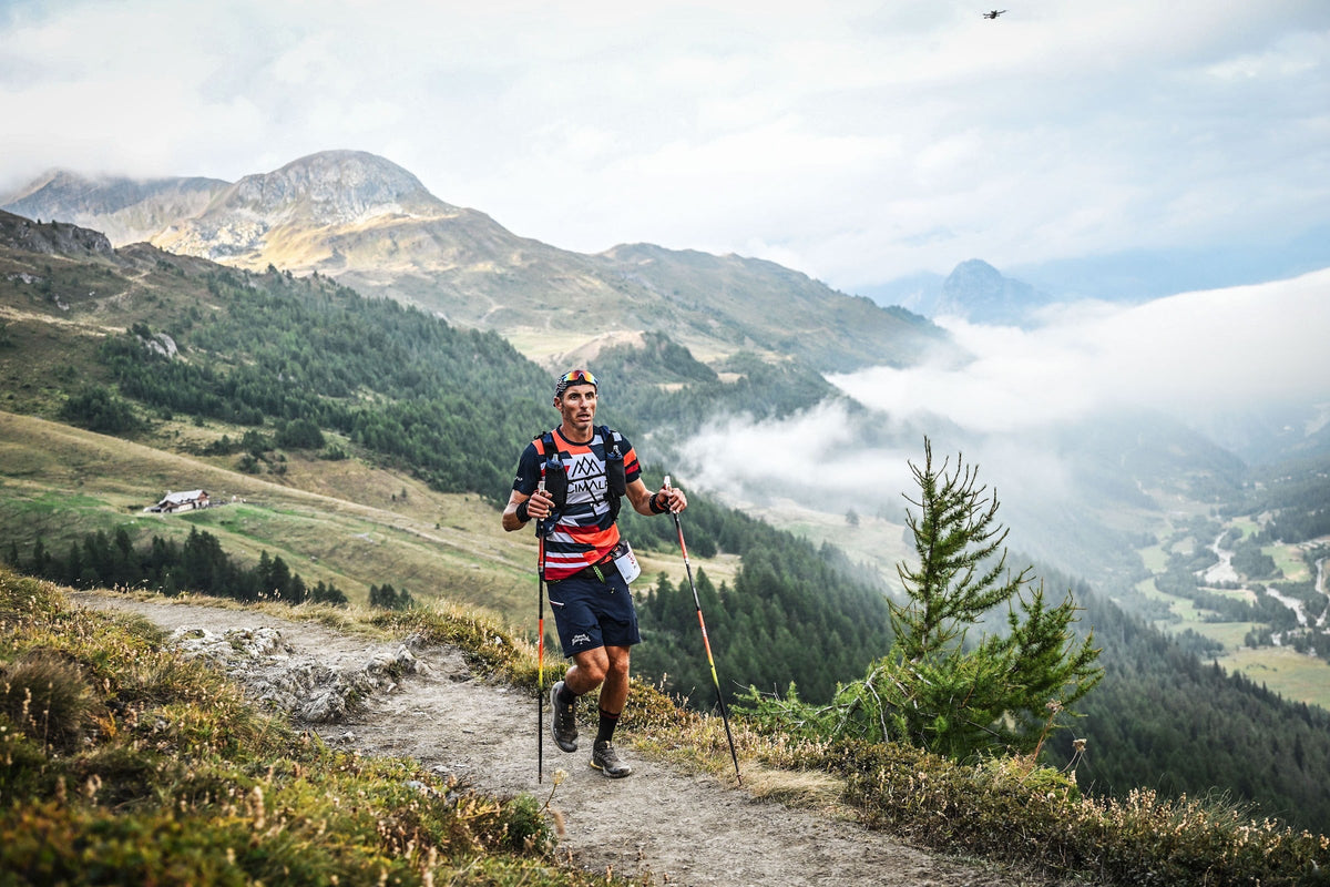 Coureur de l'UTMB face à une vallée noyée sous la mer de nuages