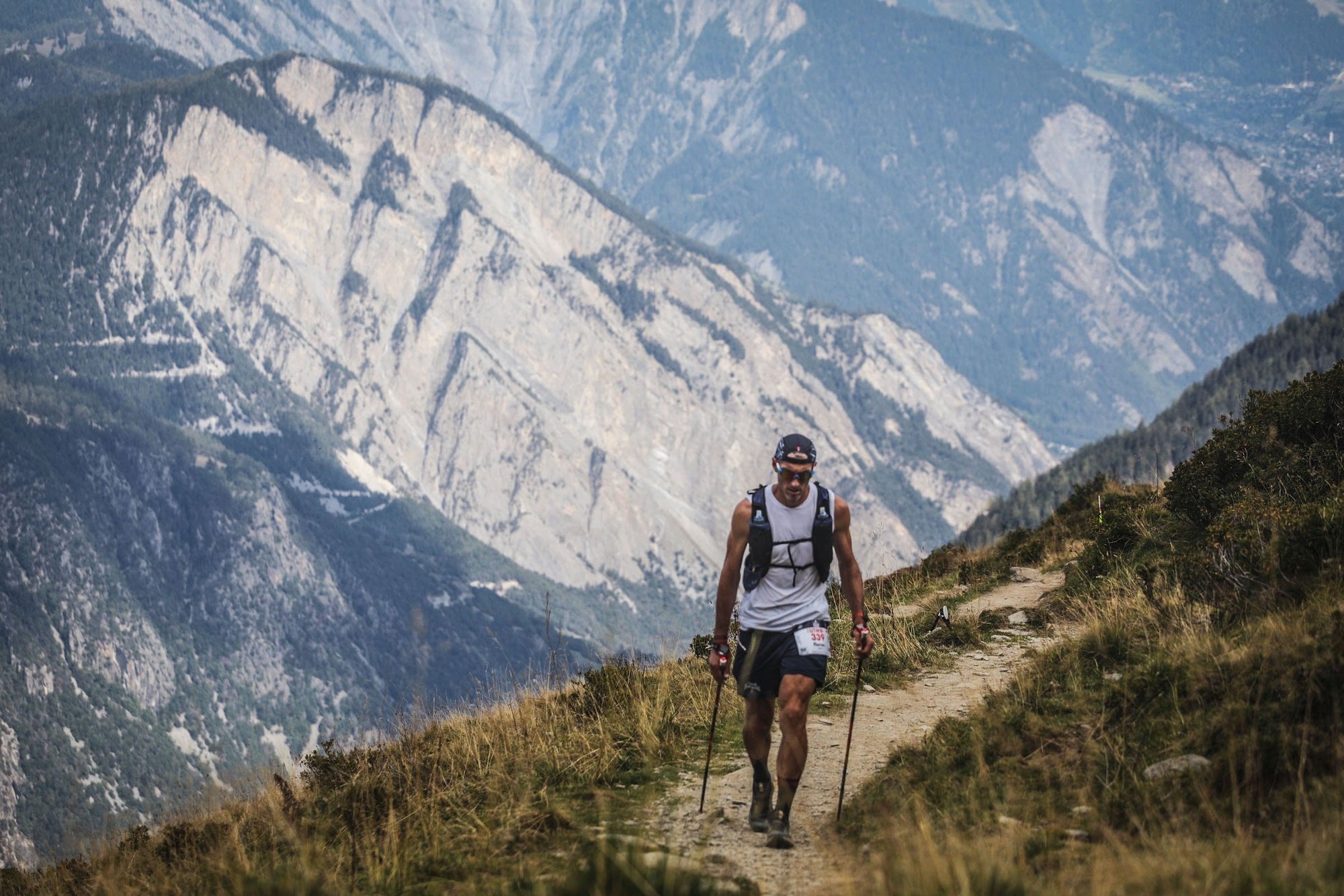 Coureur de l'UTMB face à une grande paroi rocheuse